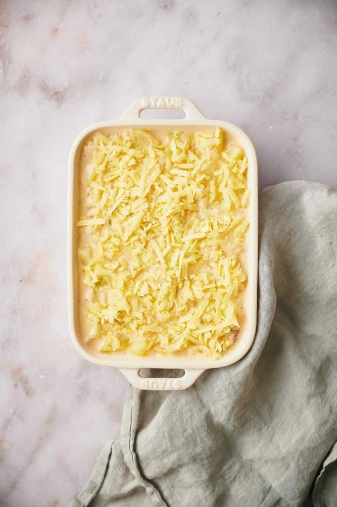 Potato casserole in oven dish with cheese sprinkled on top.