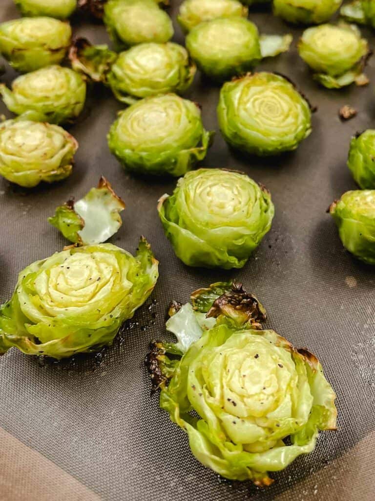 Brussels sprouts halves cooked on a baking sheet.