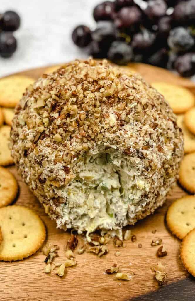A delicious pineapple cheese ball appetizer with crackers around it.