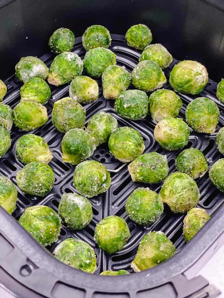 Frozen Brussel sprouts in the air fryer basket.