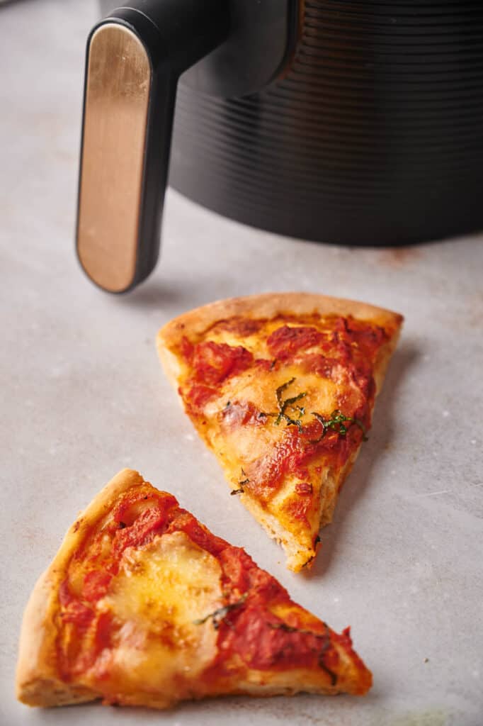 Pizza slices that have just been reheated in and air fryer, ready to eat.