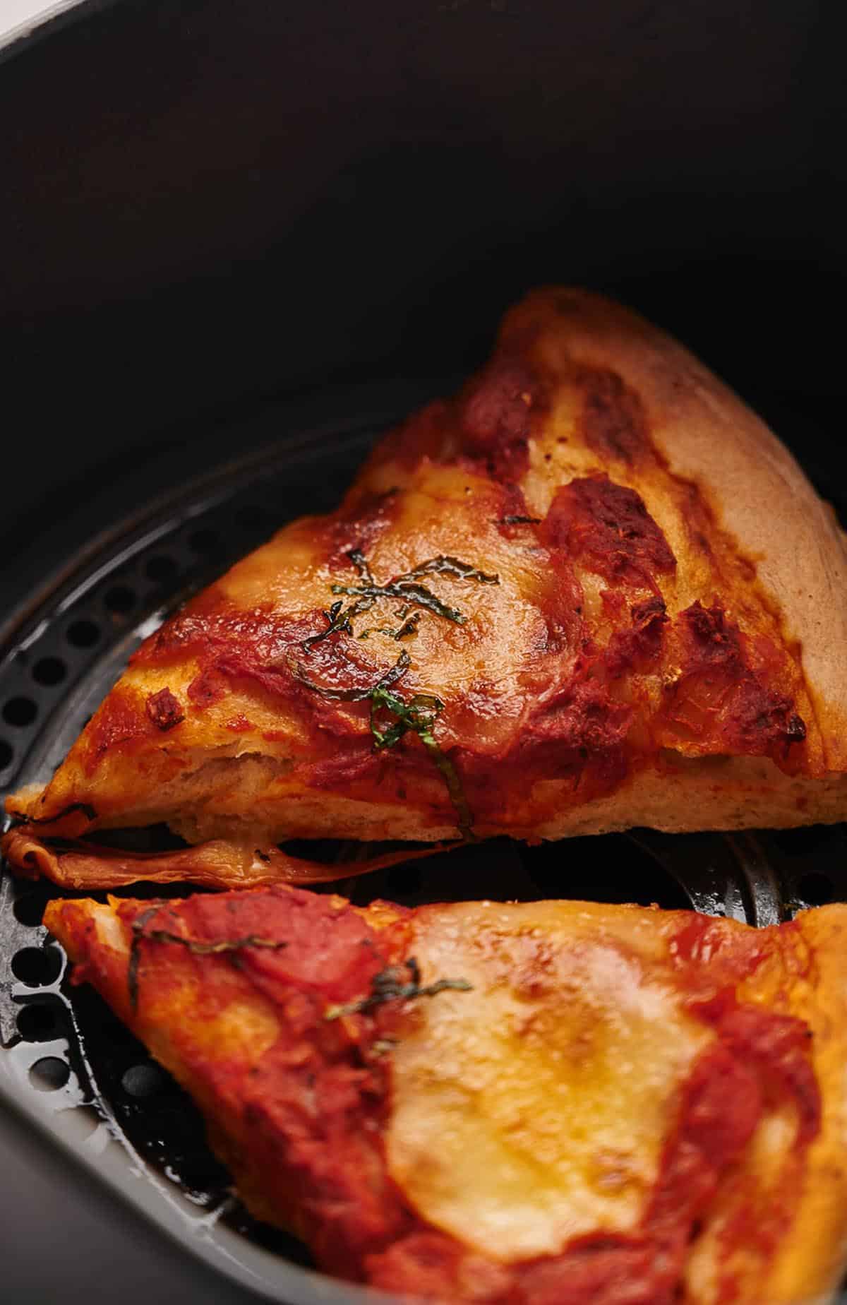 Pizza slices reheated in ana air fryer basket.