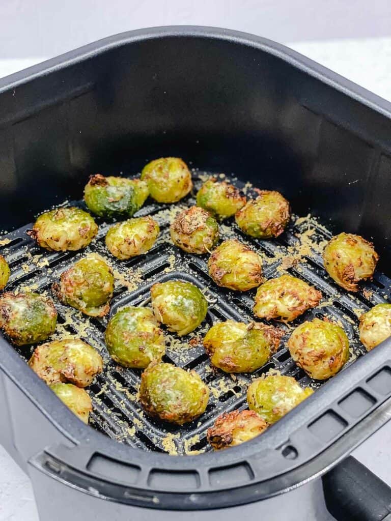 Smashed Brussels sprouts in the air fryer basket.