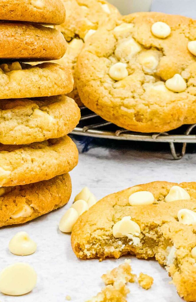 Air fryer white chocolate chip cookies one with a bite taken from it.