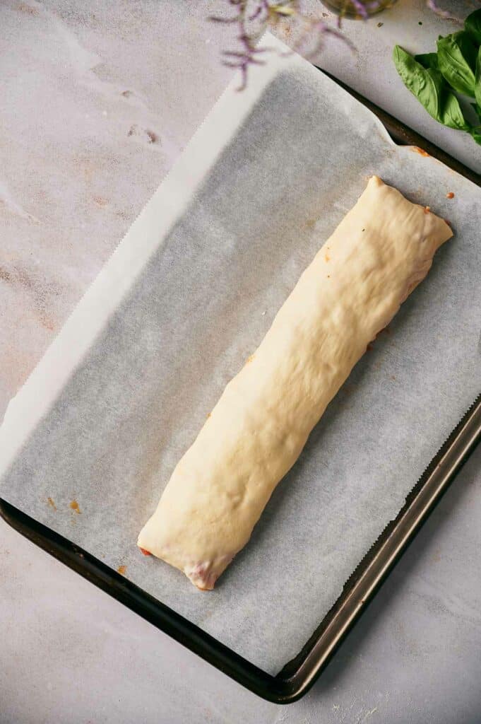 Pizza roll log on a baking sheet.
