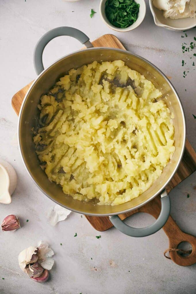 Cooked potatoes mashed in a pot.