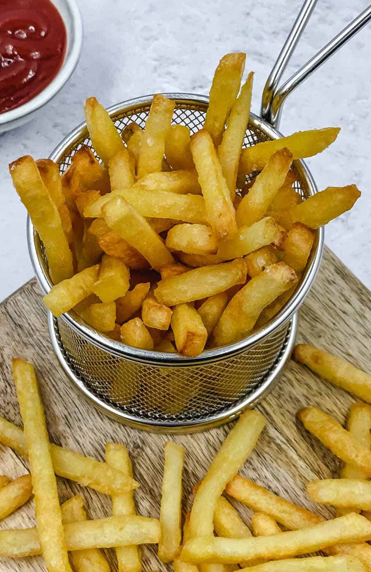 A basket full of French fries, freshly out of the air fryer.