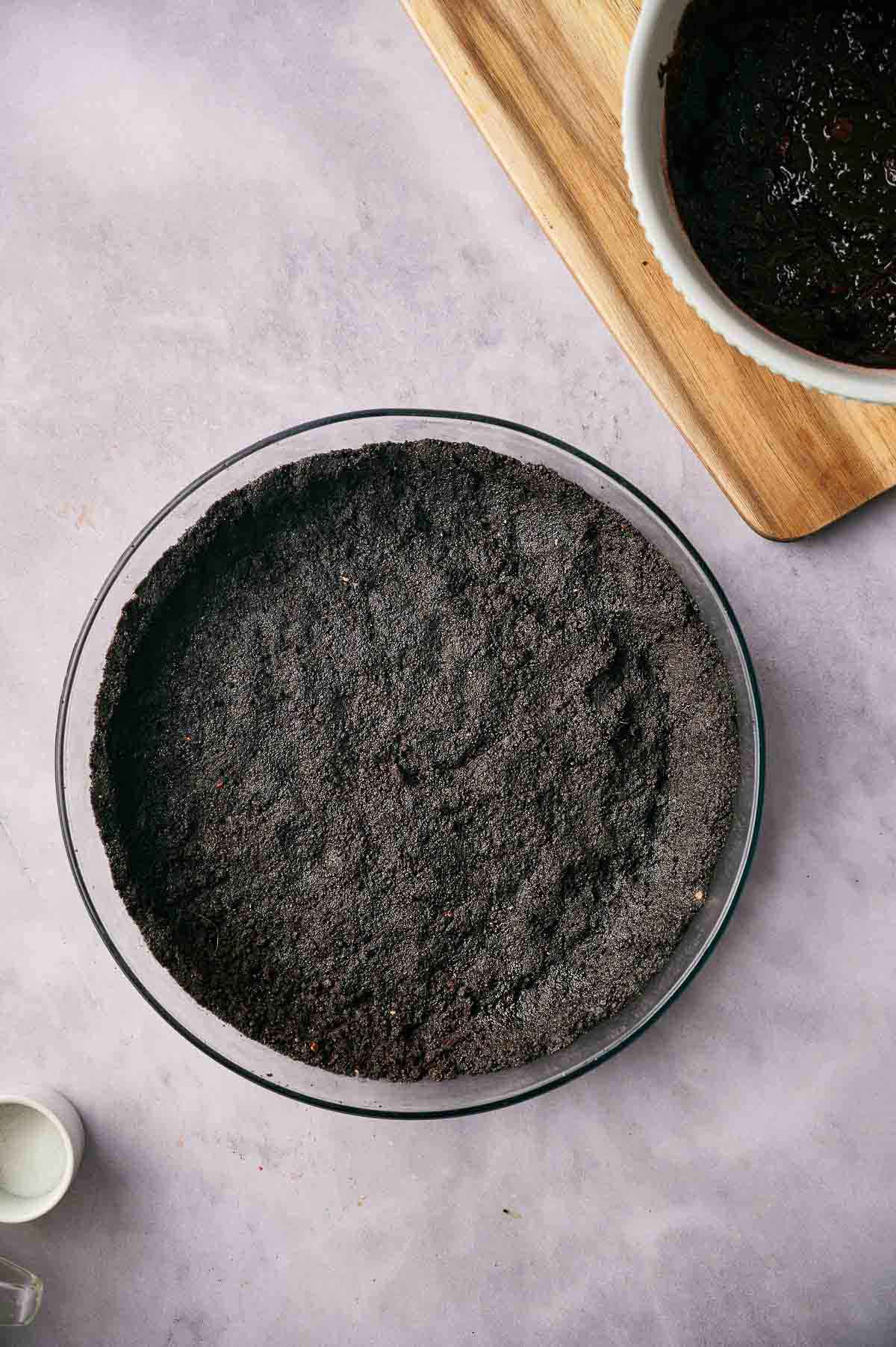 Oreo pie crust in a pie dish.