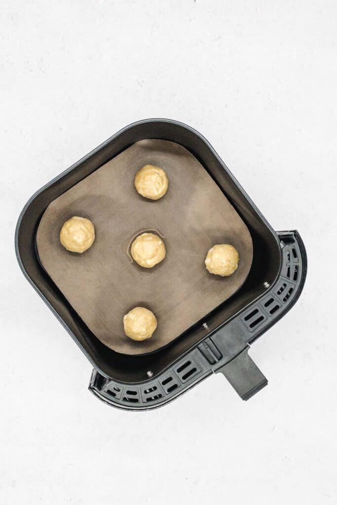 White chocolate chip macadamia nuts cookie dough in air fryer basket.