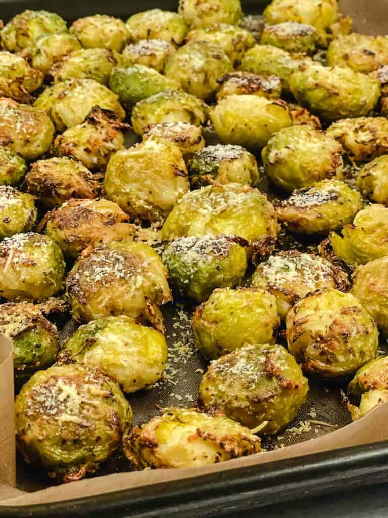 Roasted smashed Brussel sprouts on a baking sheet.