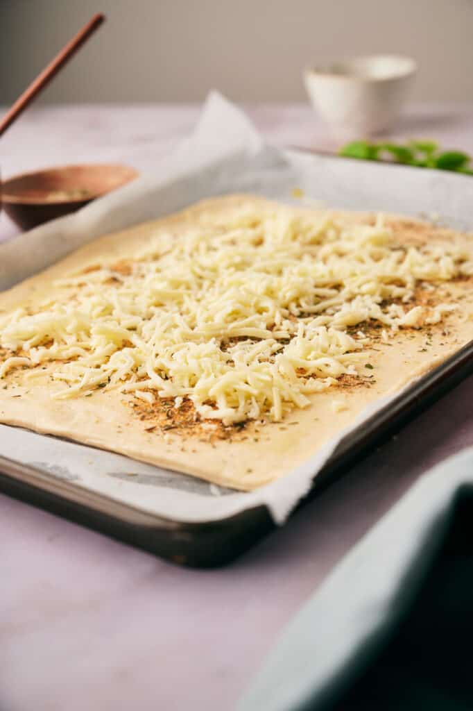 Mozzarella added to artichoke pizza.