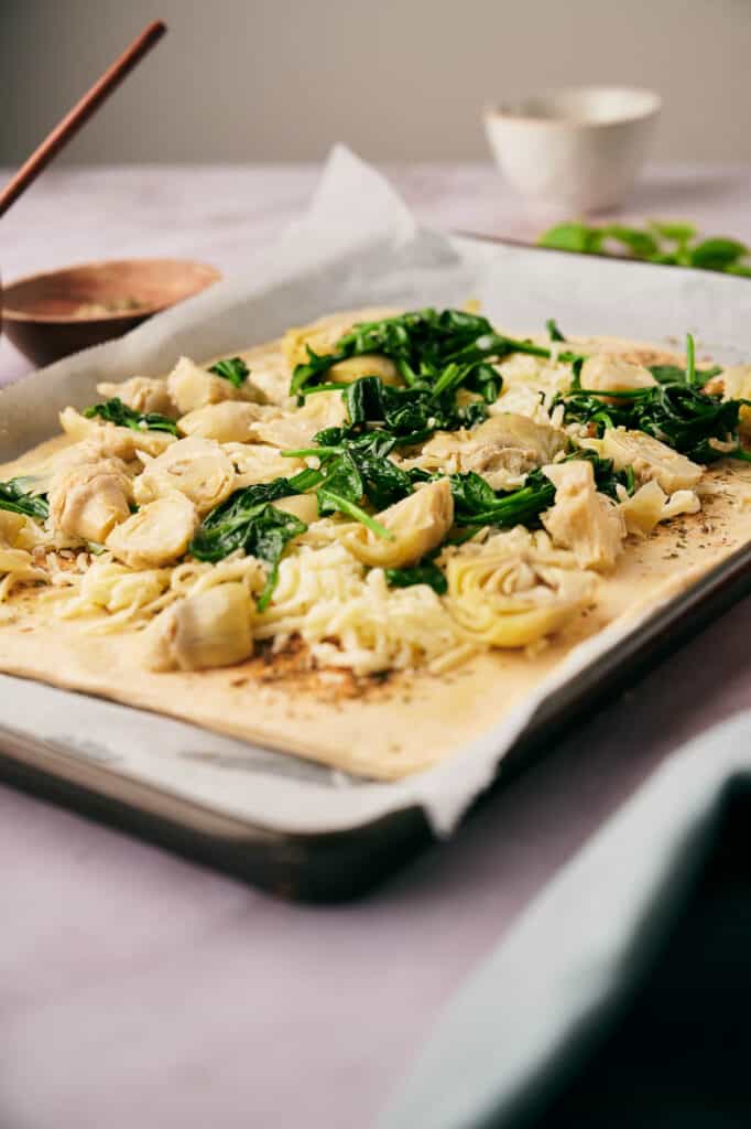 Artichoke hearts and baby spinach pizza toppings added.