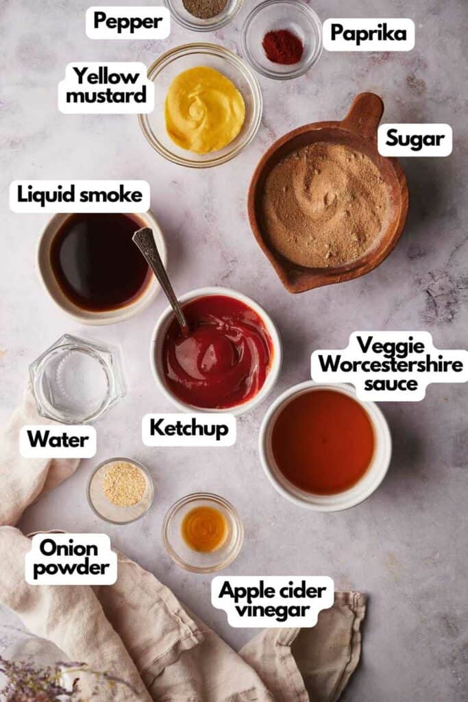 Ingredients needed, yellow mustard, black pepper, smoked paprika, light brown sugar, vegetarian Worcestershire sauce, apple cider vinegar, tomato ketchup, onion powder, water, and liquid smoke.