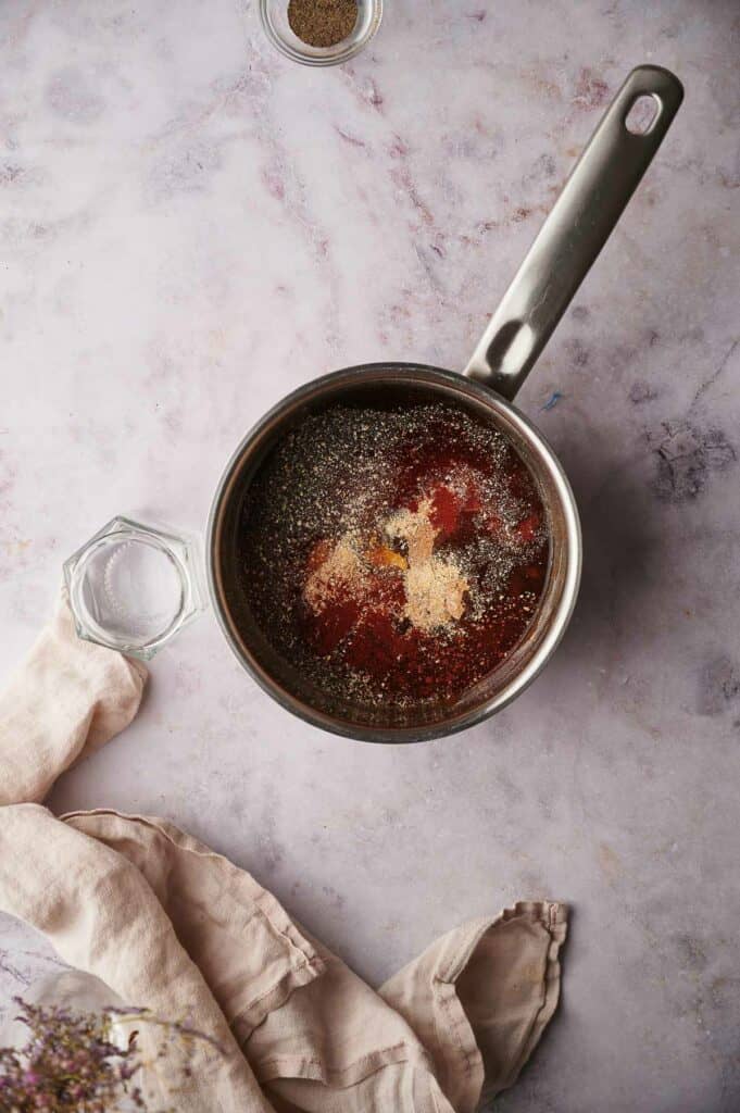 Adding black pepper and onion powder into the pan.