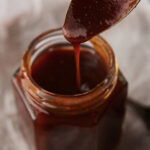 Homemade BBQ sauce with a spoon of it dripping into the jar.