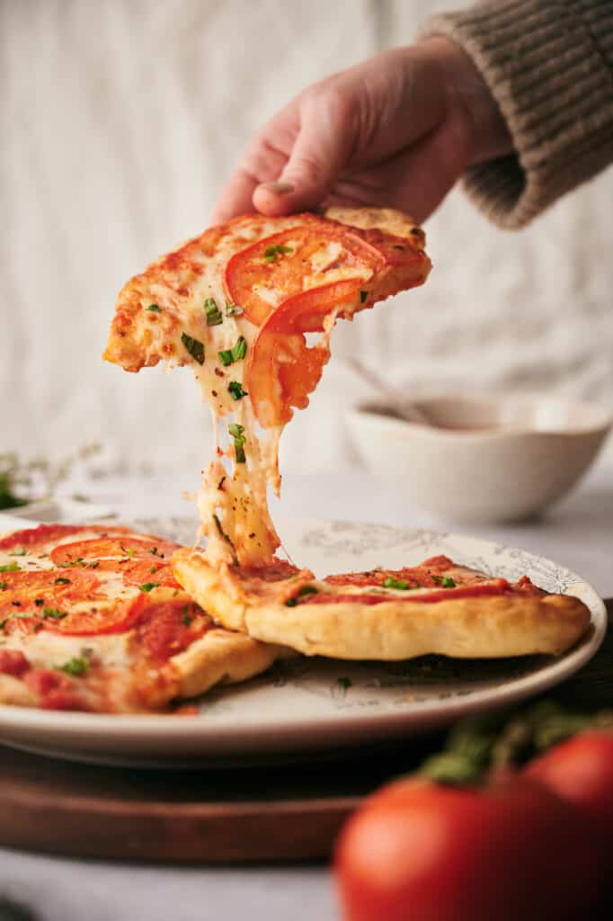 Someone helping themselves to s slice of flatbread pizza.