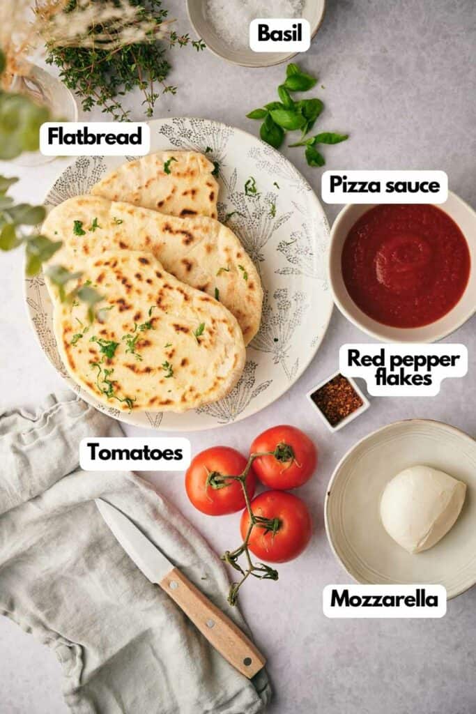 Ingredients needed, flat bread, fresh basil, pizza sauce, red pepper flakes, fresh mozzarella cheese, and tomatoes.
