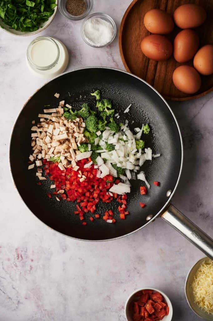 Vegetables in a skillet uncooked.
