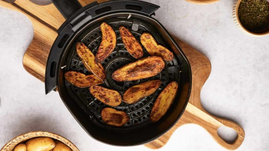 Fingerling potatoes in an air fryer basket.