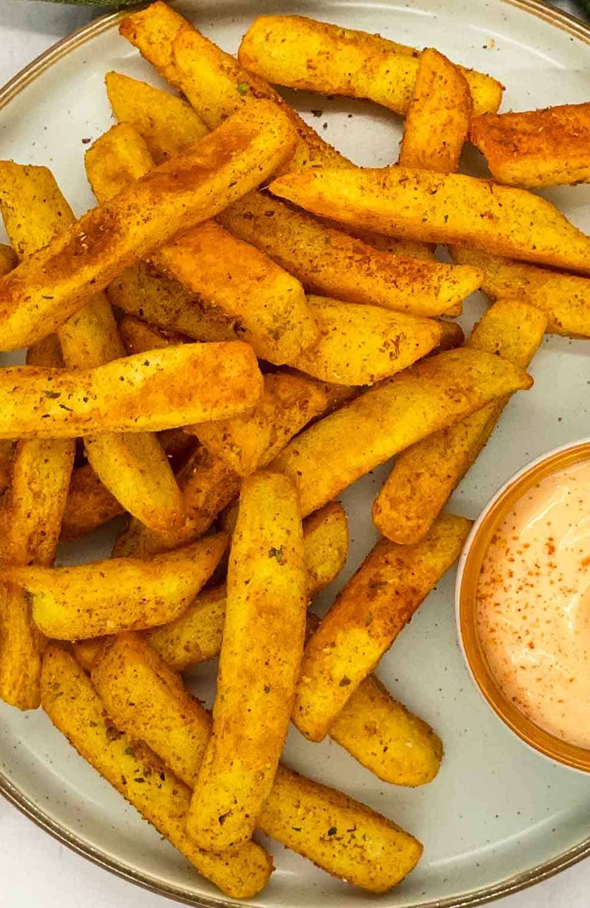 Crispy air fryer peri peri fries on a plate.