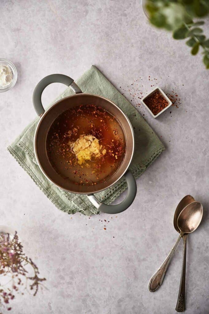 Adding cornstarch to saucepan.