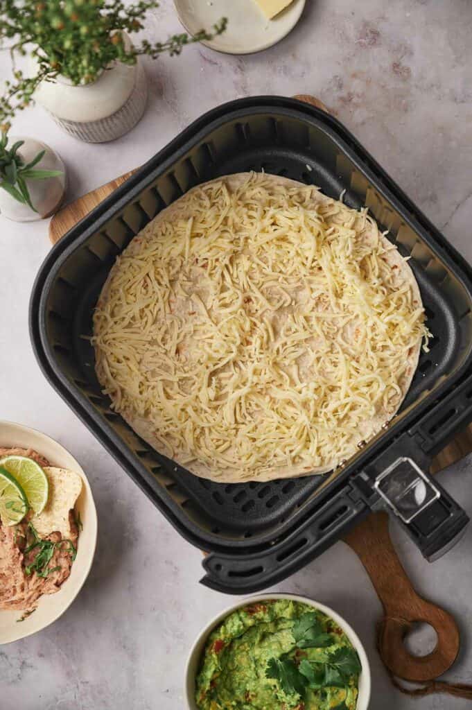 Cheese placed on a flour tortilla.