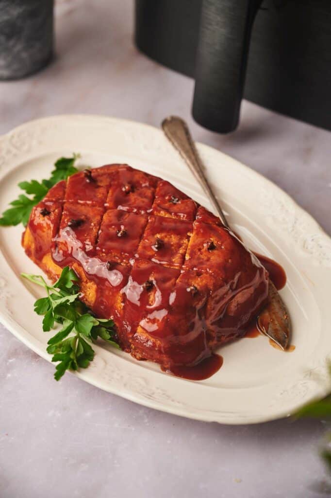 Delicious vegan ham with a maple glaze on a serving platter.