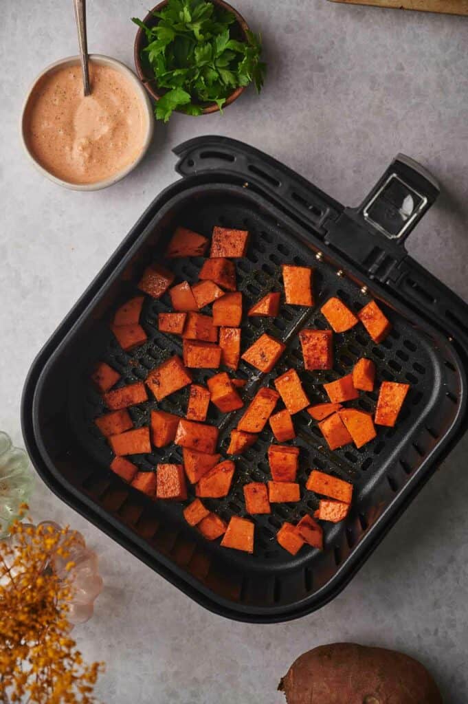 Sweet potato chunks in air fryer basket.