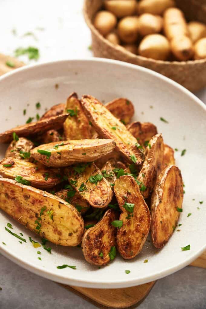 A large bowl with roasted fingerling potatoes ready to eat.