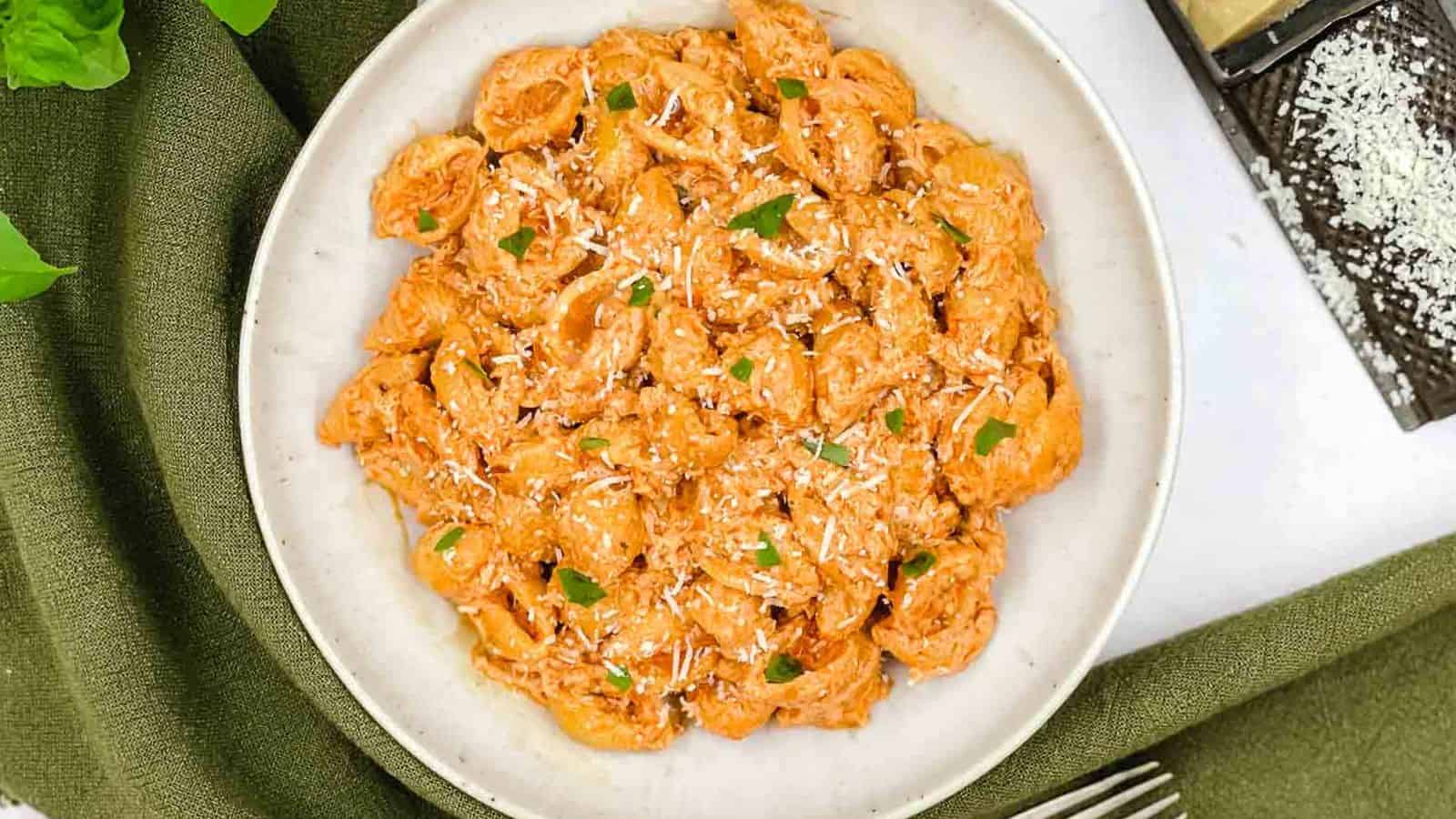 A plate of pasta with sauce and parmesan cheese.