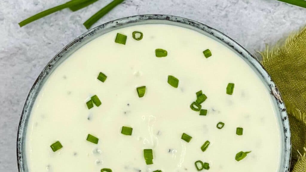 Sour cream and chives dip in a dish.