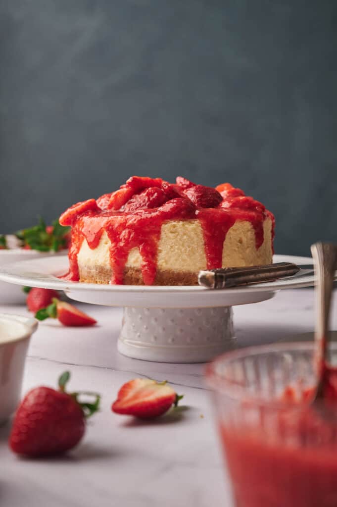 Strawberry cheesecake on a cake stand.