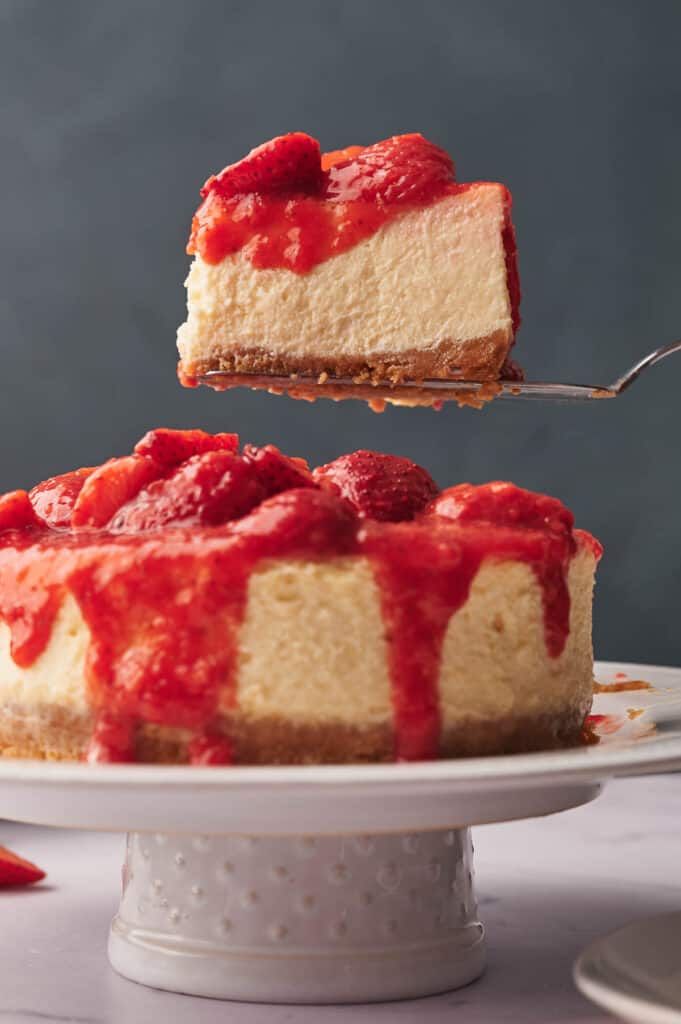 Serving a slice of strawberry cheesecake.