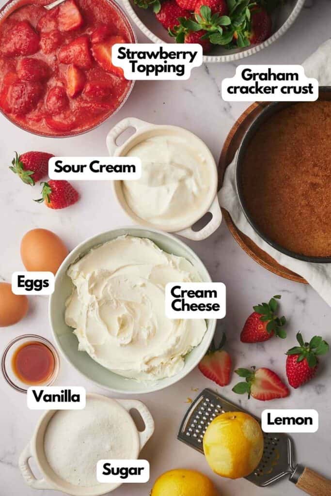 Ingredients needed; strawberry topping, Graham cracker crust, sour cream, cream cheese, lemon, vanilla extract, and eggs.
