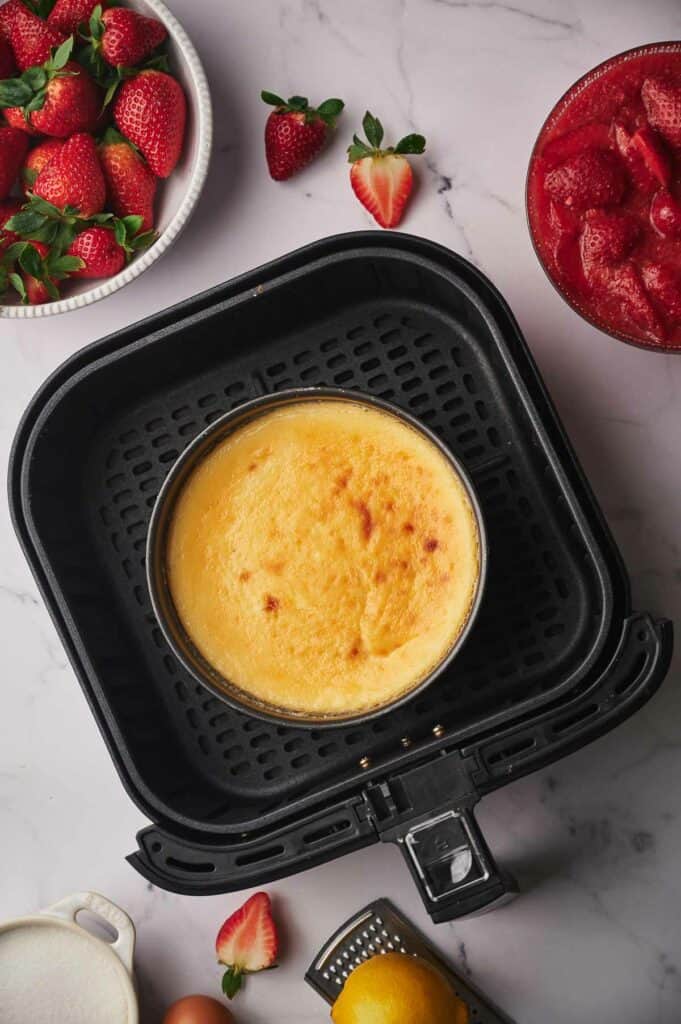 Baked cheesecake in an air fryer basket.