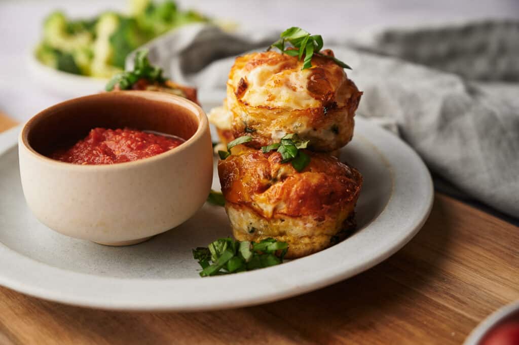 Delicious egg bites on a plate along with a bowl of dipping sauce.