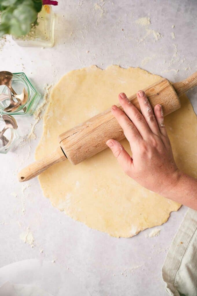 Someone using a rolling pin to roll out a pie crust.