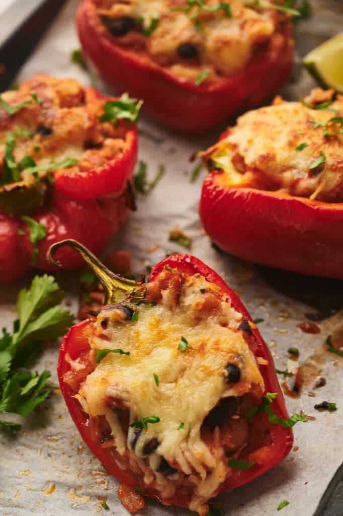 Tasty freshly cooked vegetarian stuffed peppers on a baking sheet.