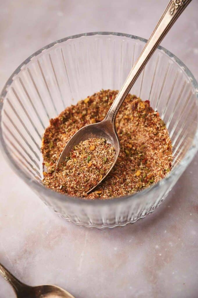 A dish with taco seasoning with a spoon with seasoning on it.