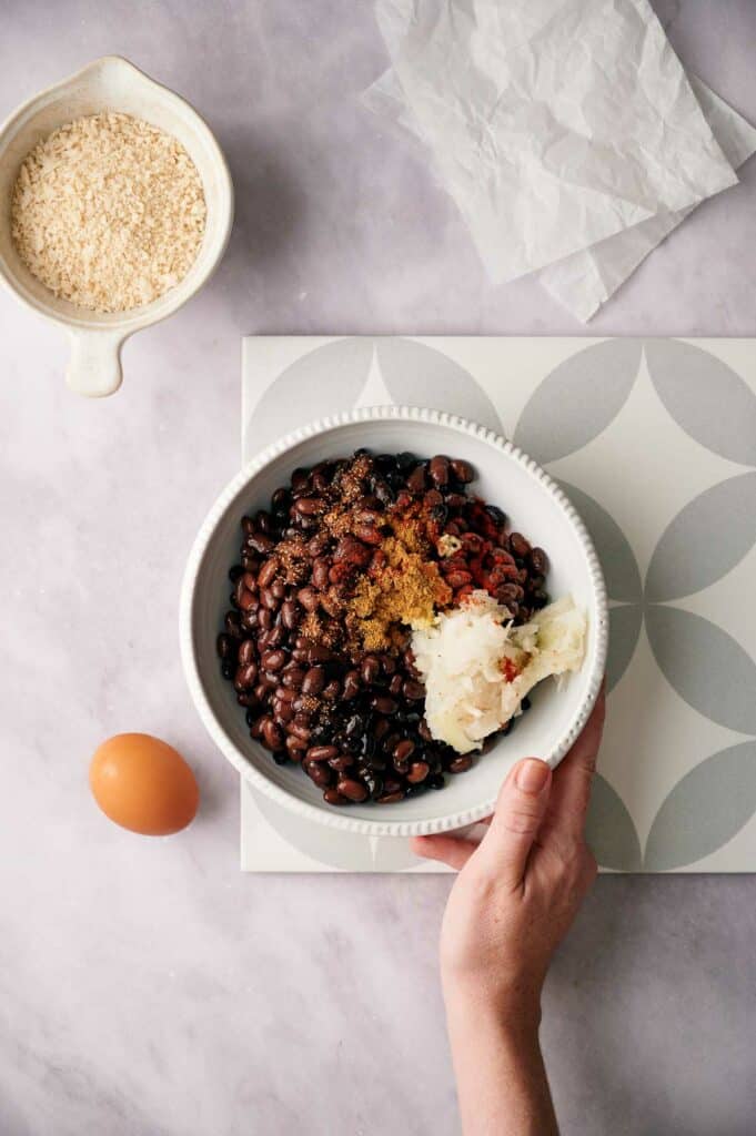 Someone holding a bowl of unmixed ingredients.