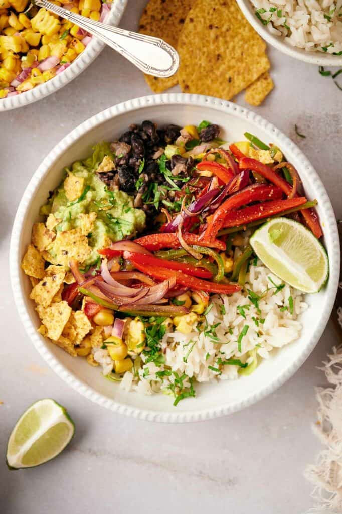 A close up of a copycat Chipotle burrito bowl, with lime wedges on it.