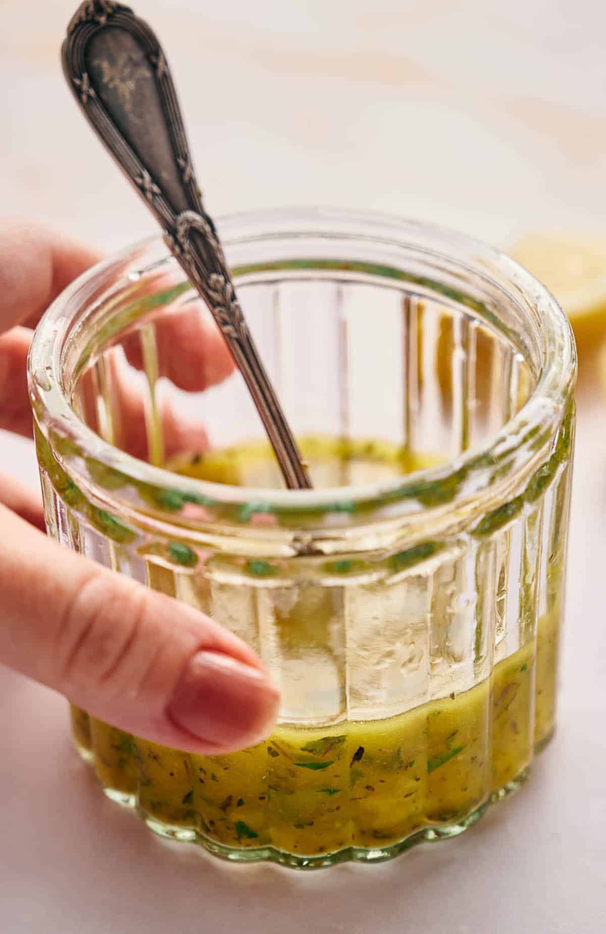 Someone holding a jar of Italian dressing.