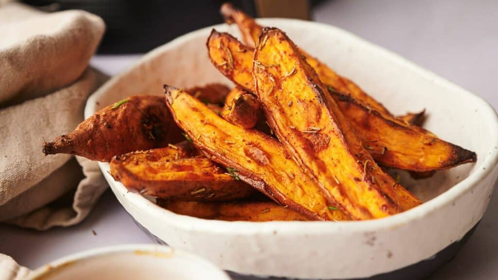 Sweet potato wedges in a white bowl.