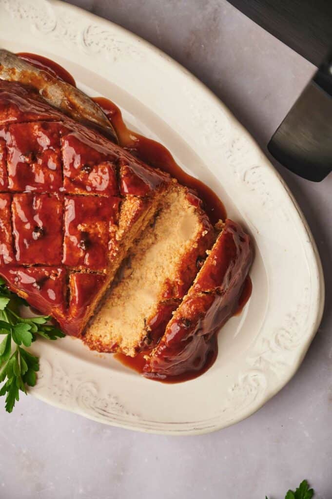 Vegan ham sliced and on a serving dish.