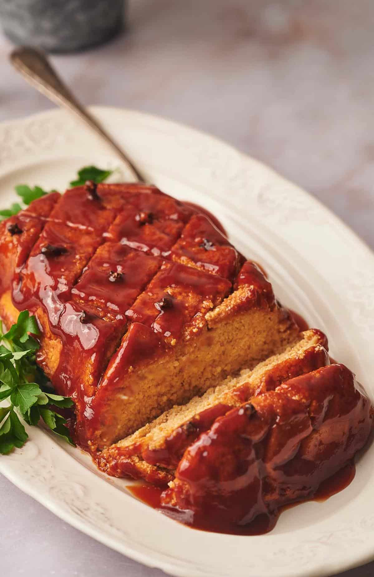 Vegan ham sliced and on a serving dish.