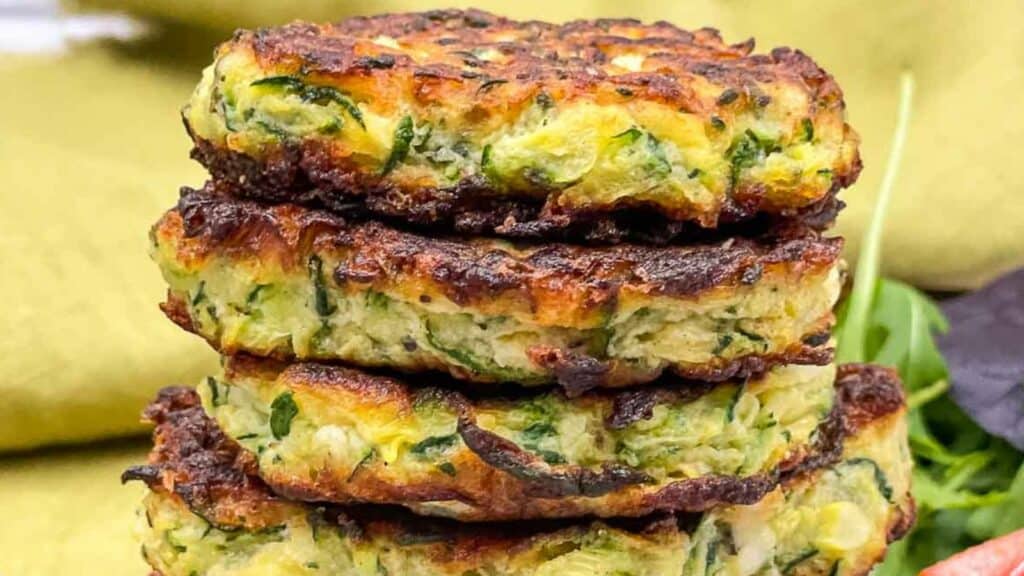 Zucchini fritters stacked up on each other. 
