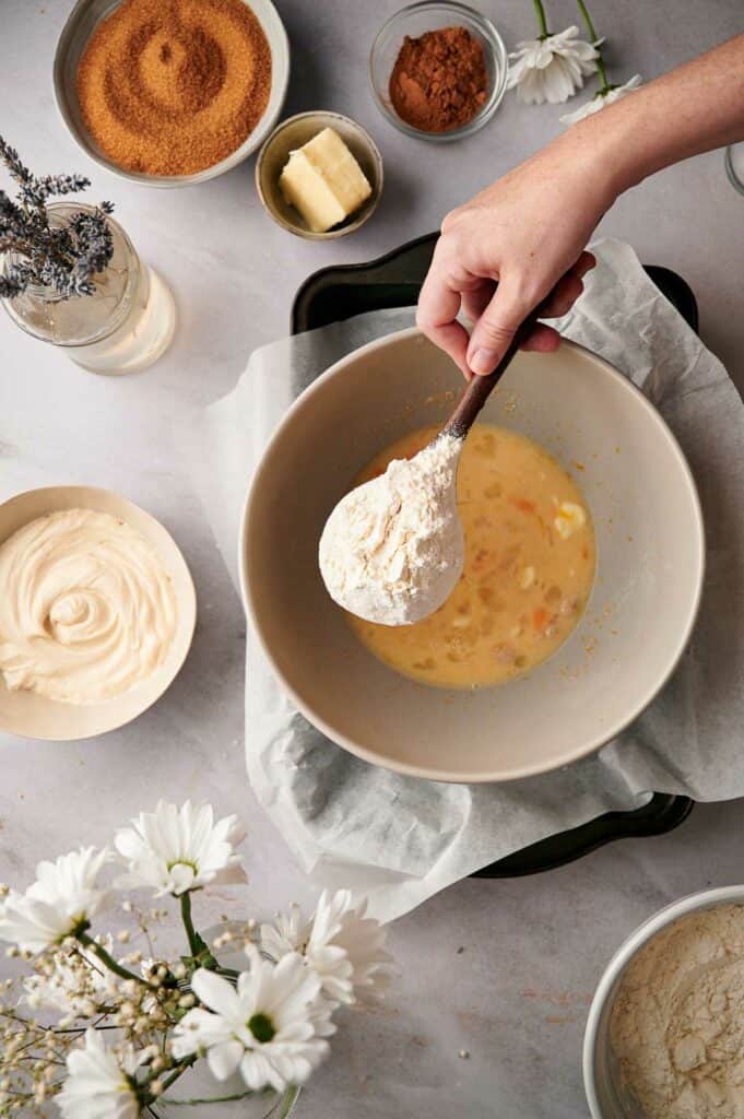 Adding flour to the mixing bowl.