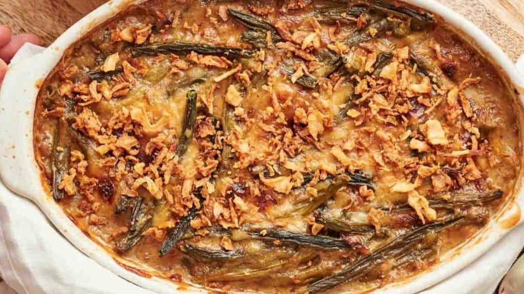 A white dish with a dish of green bean casserole in it.