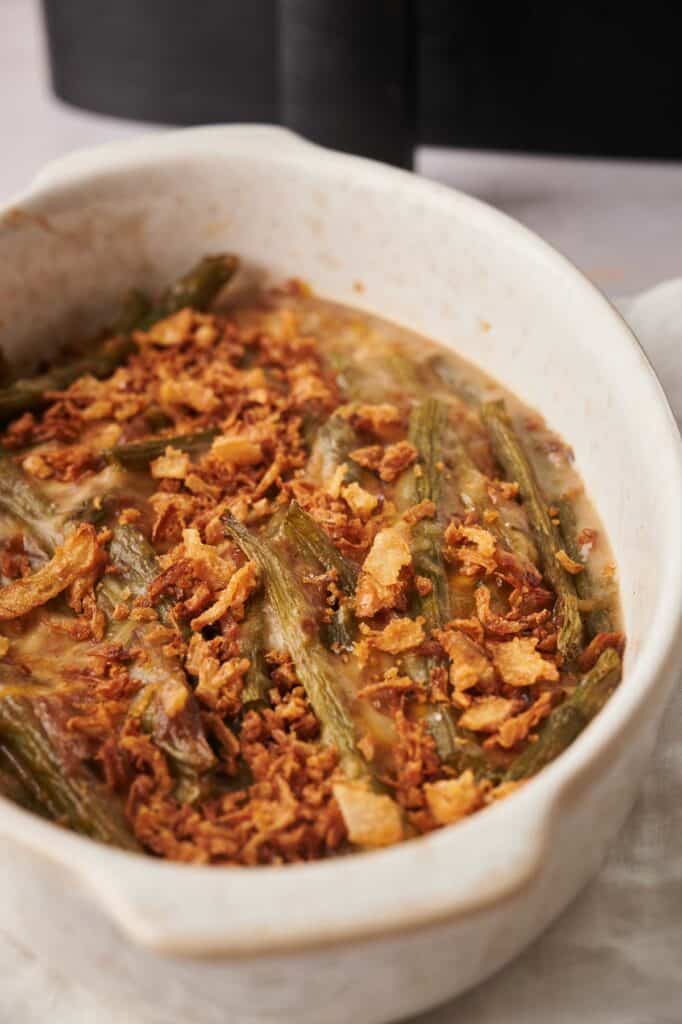 Green bean casserole with onions in a white dish.
