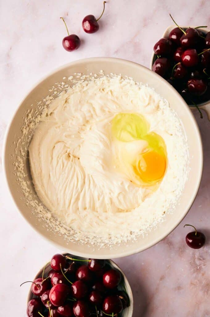 A bowl of whipped cream cheese and an egg.